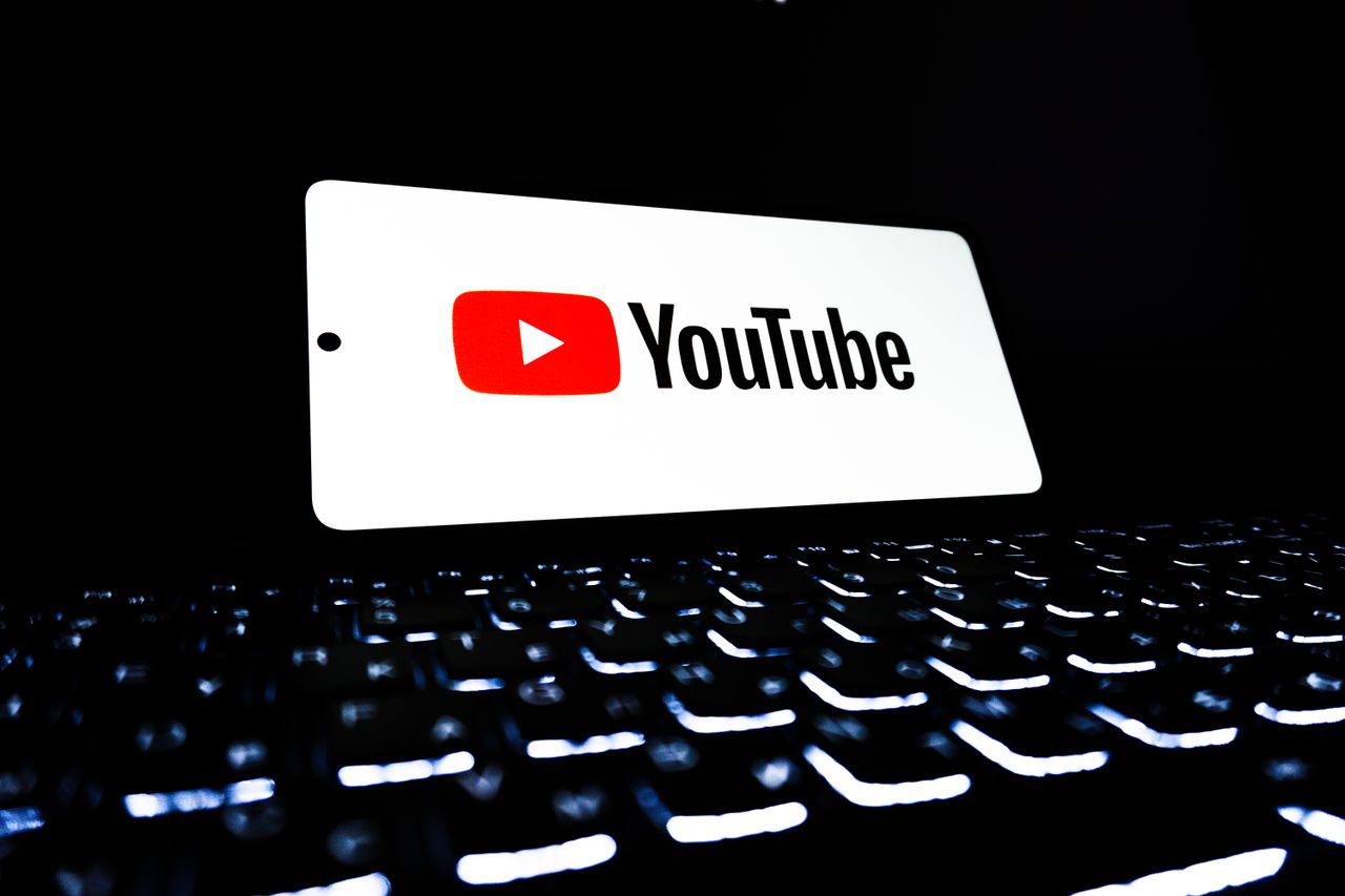 heros-img YouTube app icon displayed on a smartphone over an illuminated keyboard, representing digital media and online streaming.