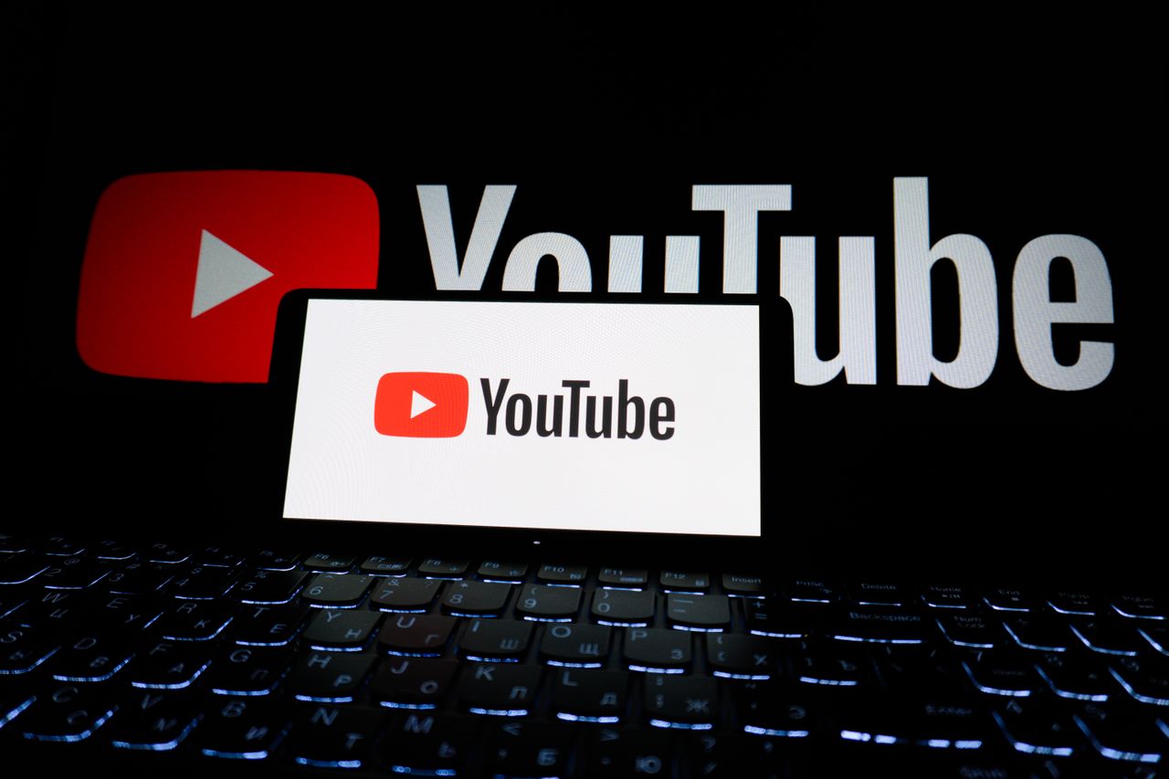 about-us-01 Close-up of YouTube logo displayed on a laptop screen in a dark environment.